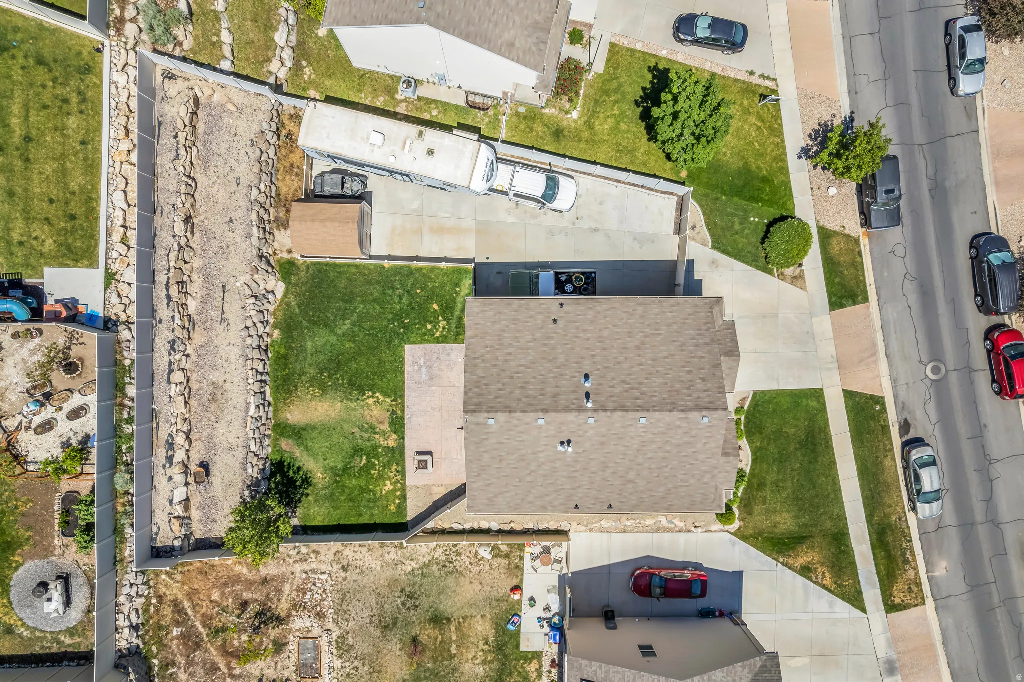 Property featuring a composition shingle roof, concrete driveway, and established lawn areas
