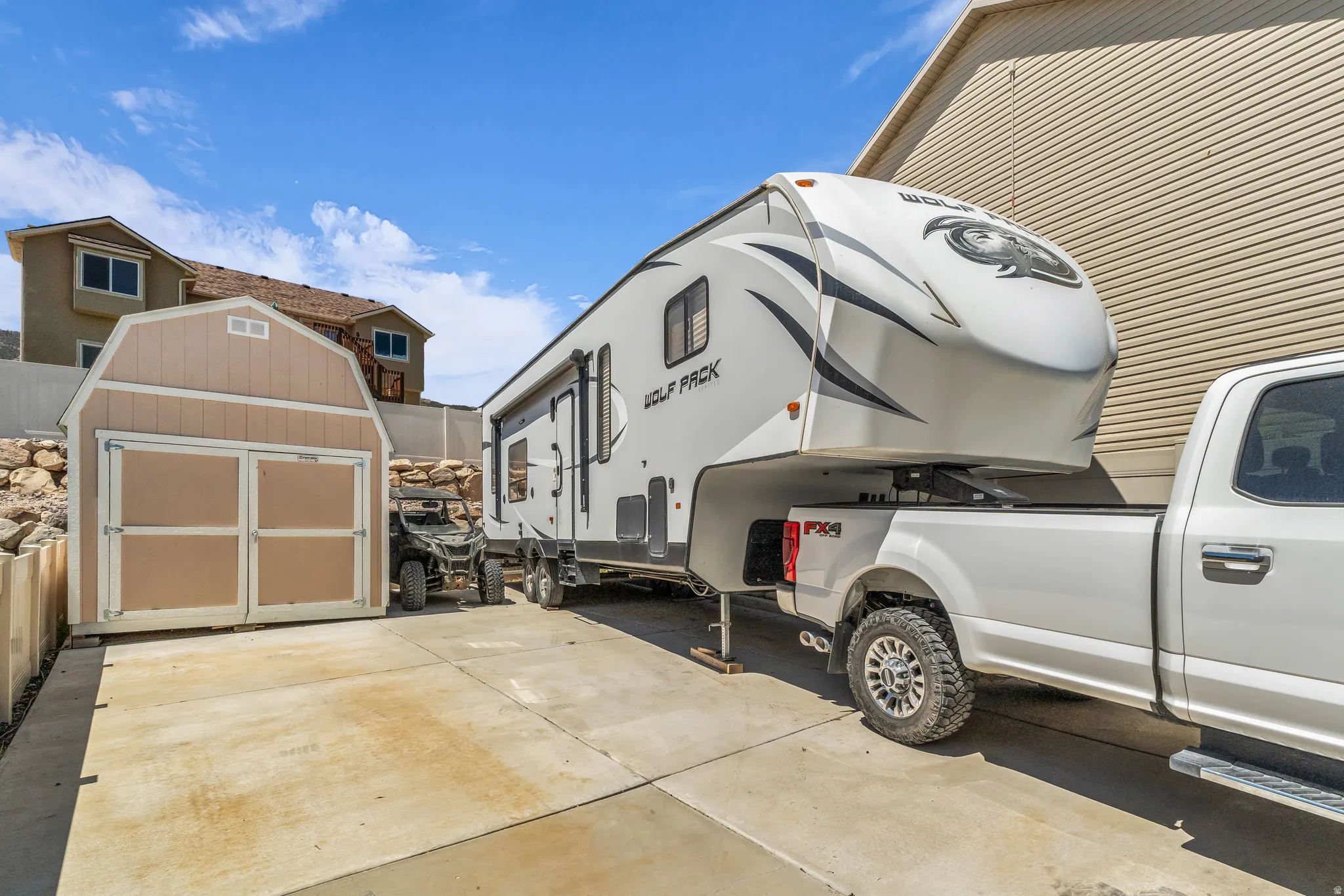 Paved side yard area featuring a storage shed with double doors