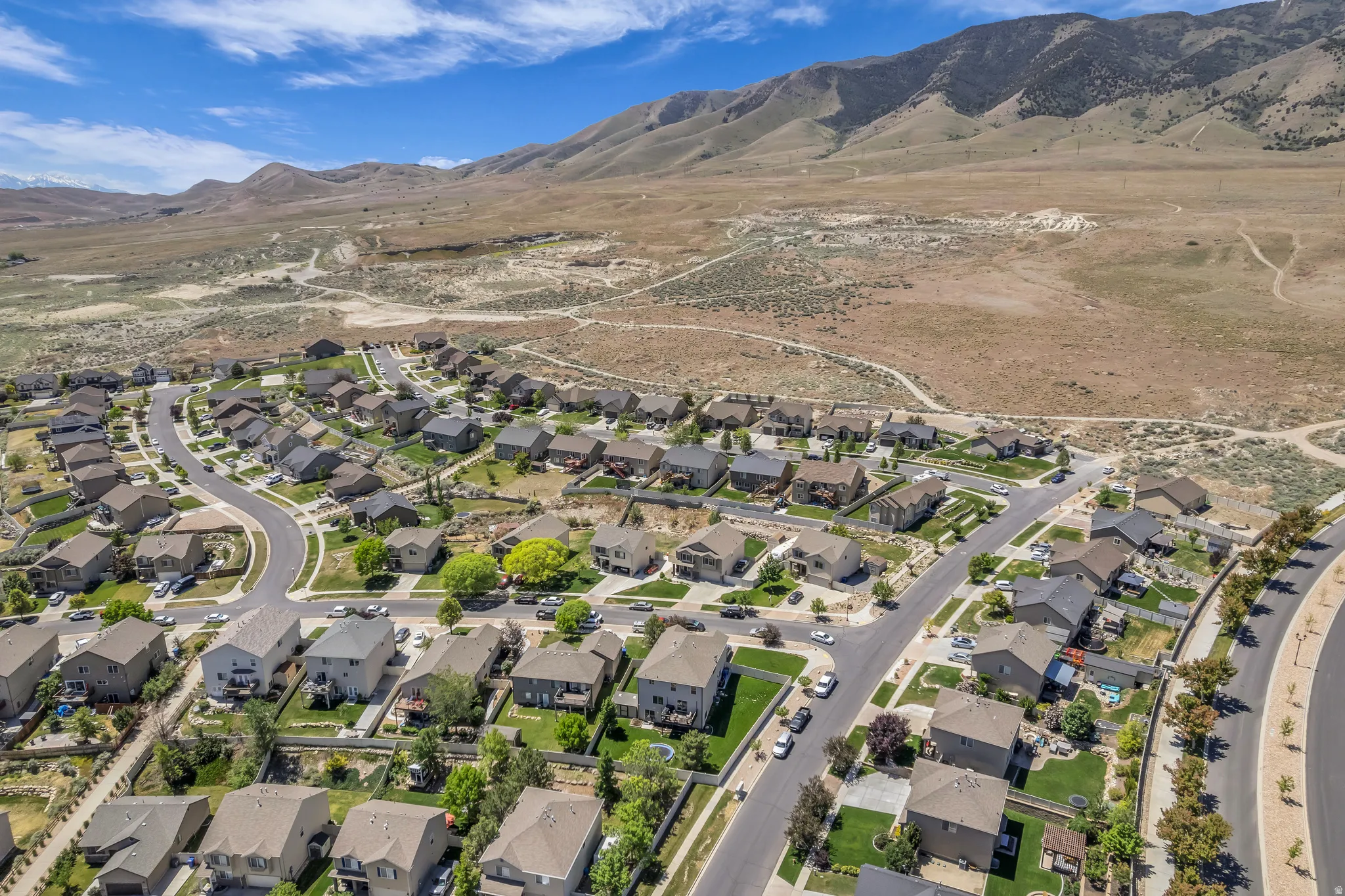 Residential community situated at the base of expansive mountains, featuring varied architecture and mature landscaping