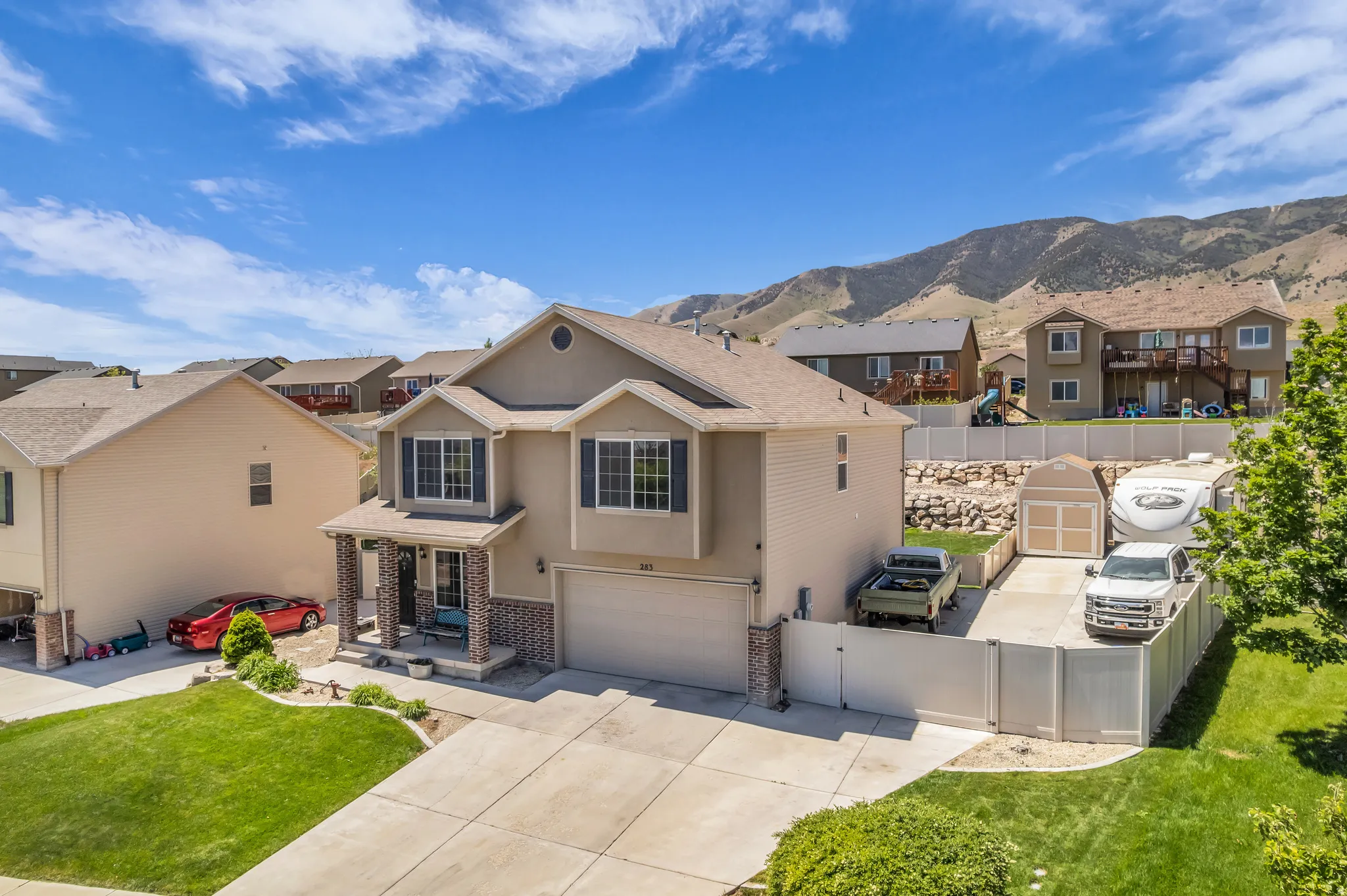Two-story residence featuring a covered front porch with brick columns, a two-car garage, and a concrete driveway