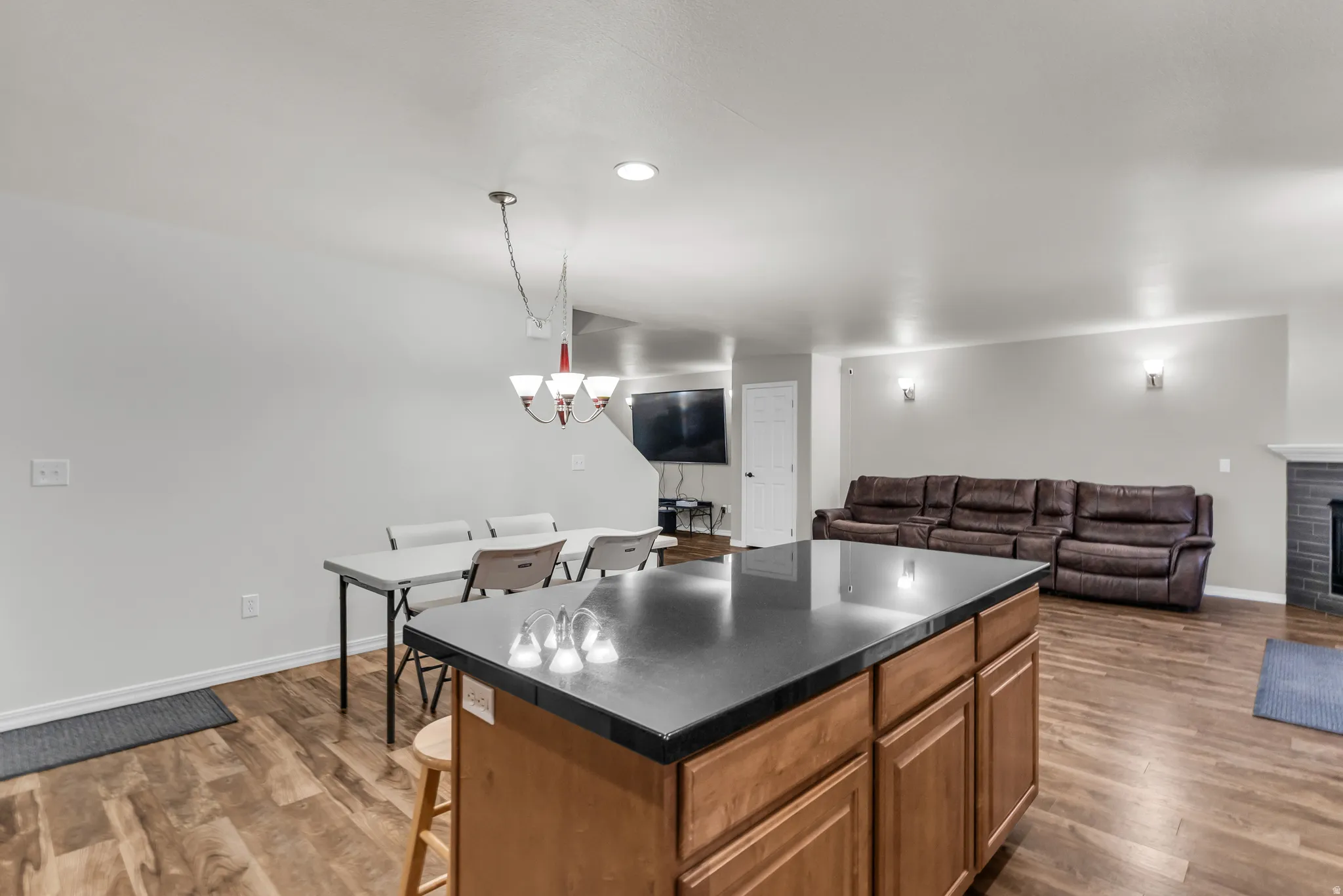 Kitchen island with dark countertop and wood cabinetry