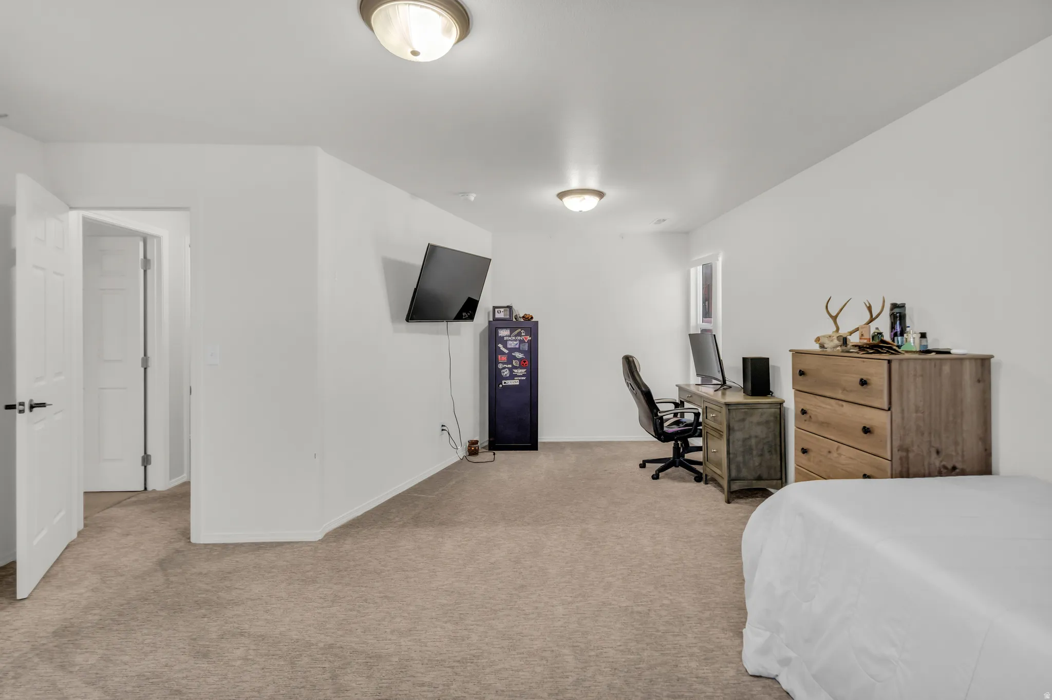 Spacious room featuring neutral carpeting and white painted walls