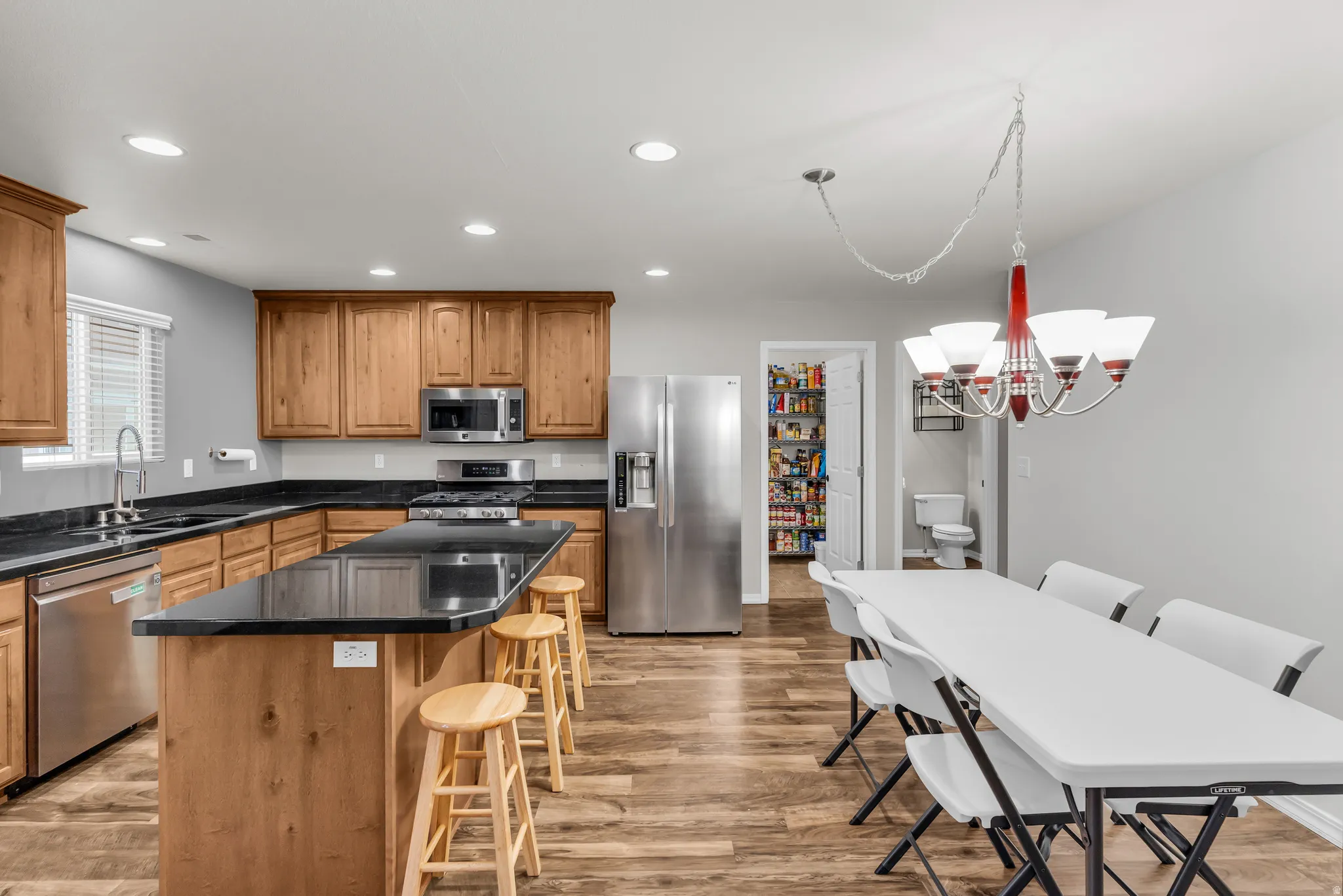 Kitchen featuring wood-finish cabinetry, dark countertops, and stainless steel appliances