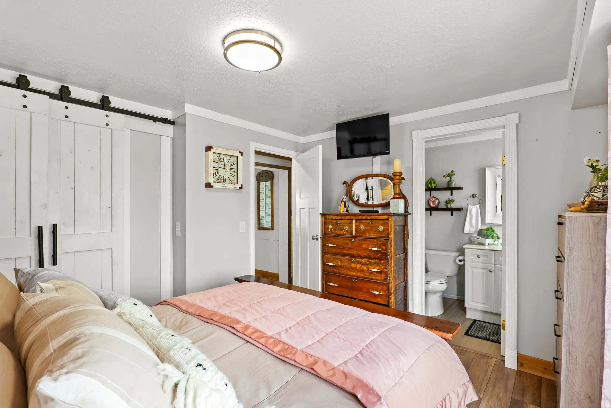 Room featuring a ceiling-mounted light fixture, crown molding, and wood-finish flooring