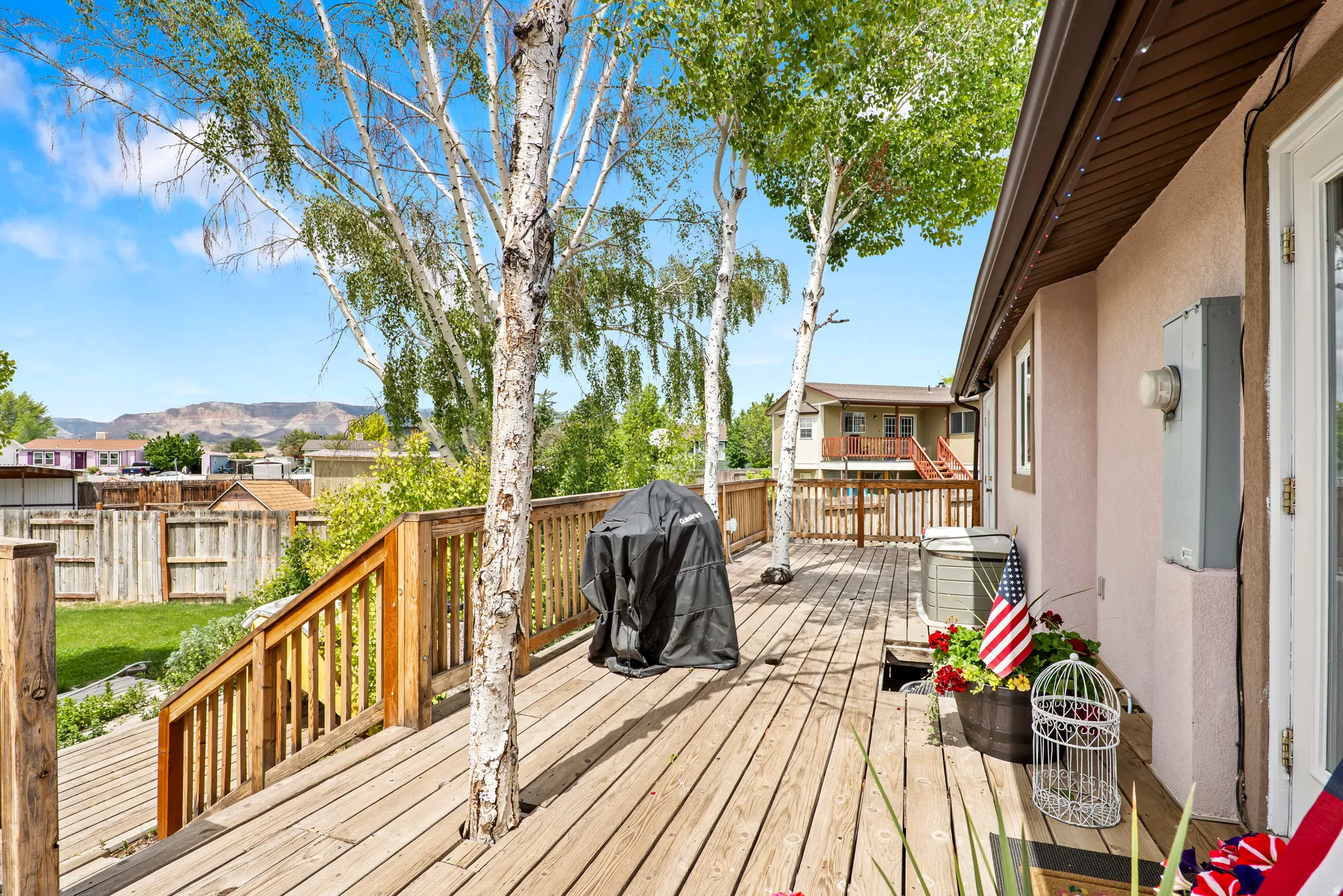 Expansive multi-level wood deck featuring integrated mature trees
