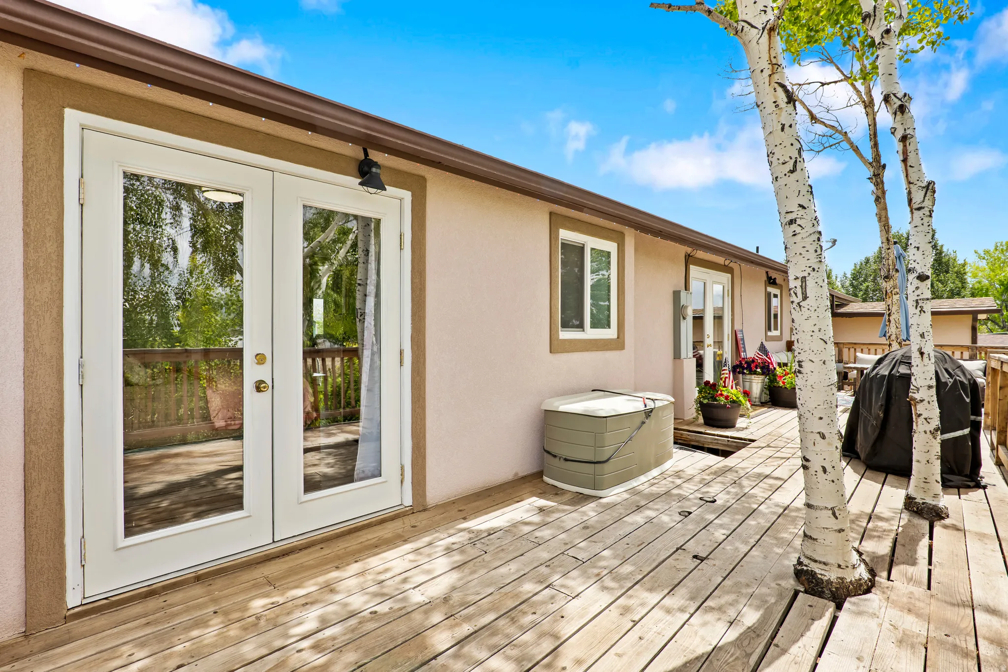 Expansive outdoor deck featuring natural wood planks and mature trees