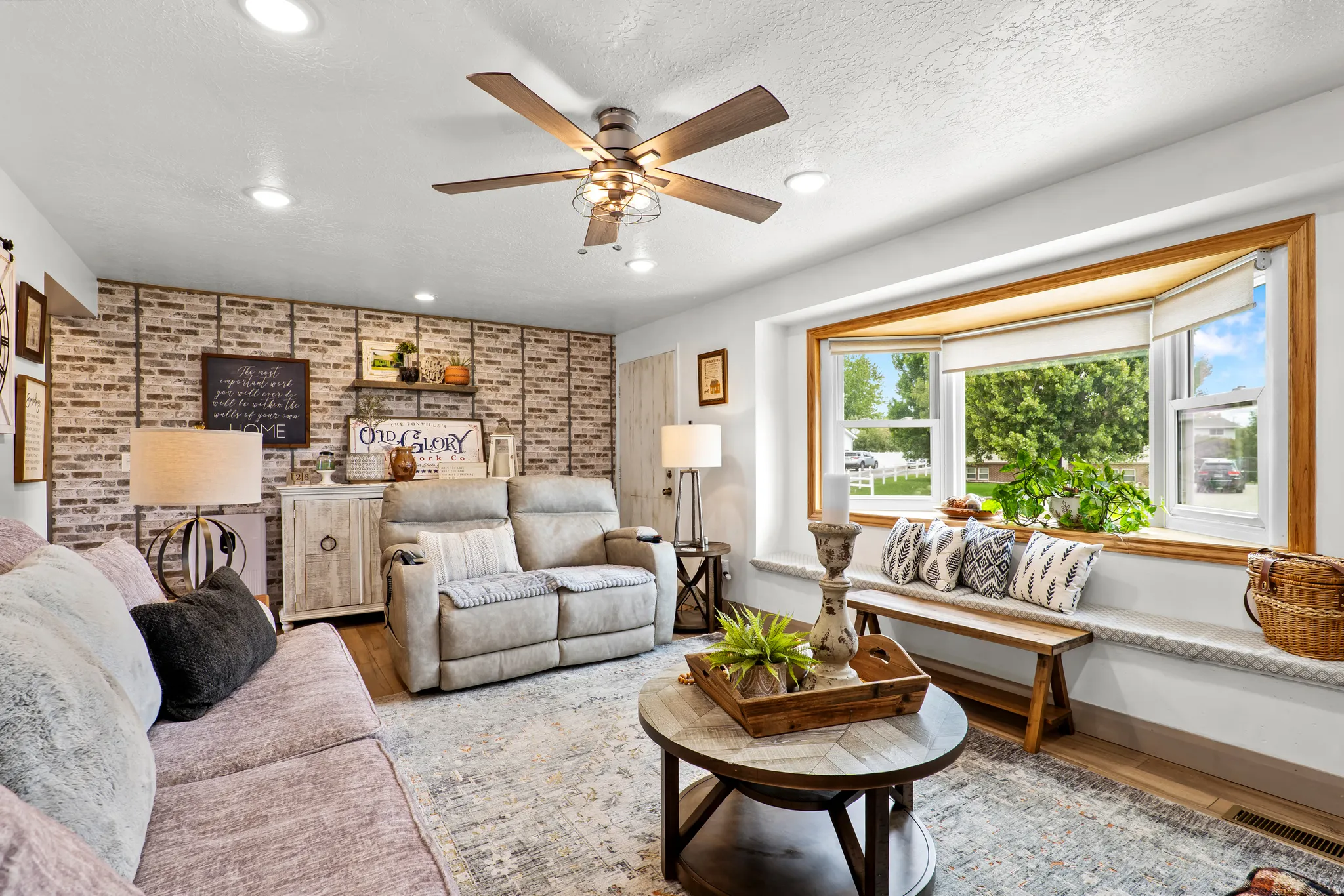 Living area featuring a prominent bay window with wood trim, recessed lighting, and a ceiling fan with light kit