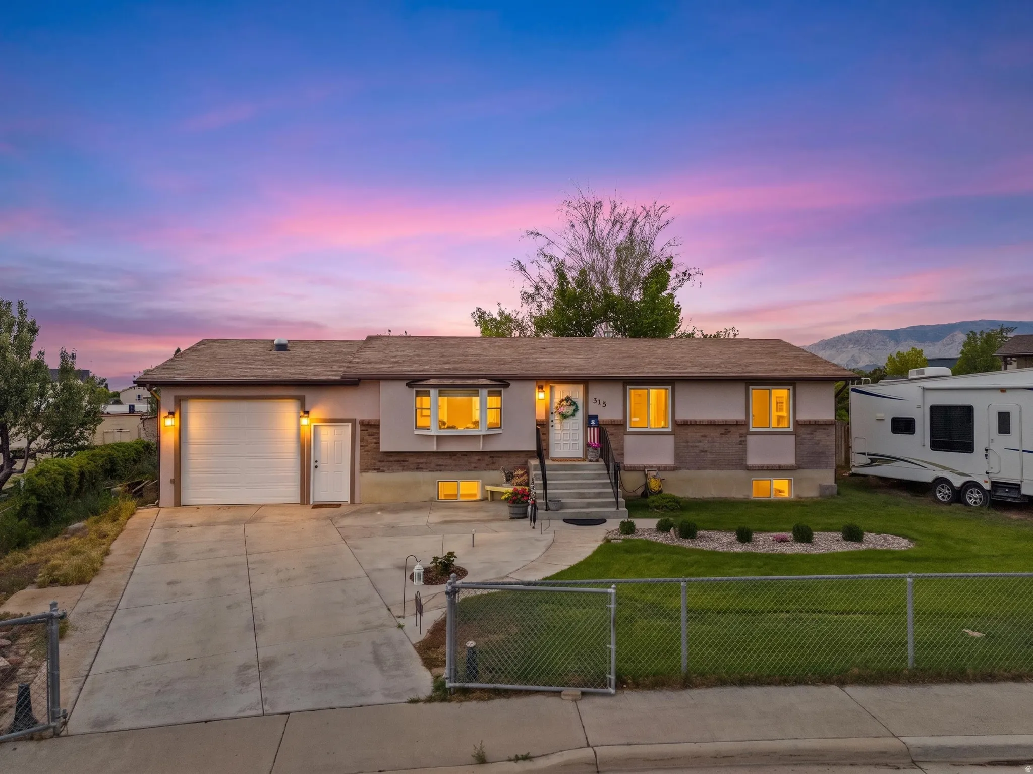 Ranch-style exterior with a single-car garage, concrete driveway, and a front lawn