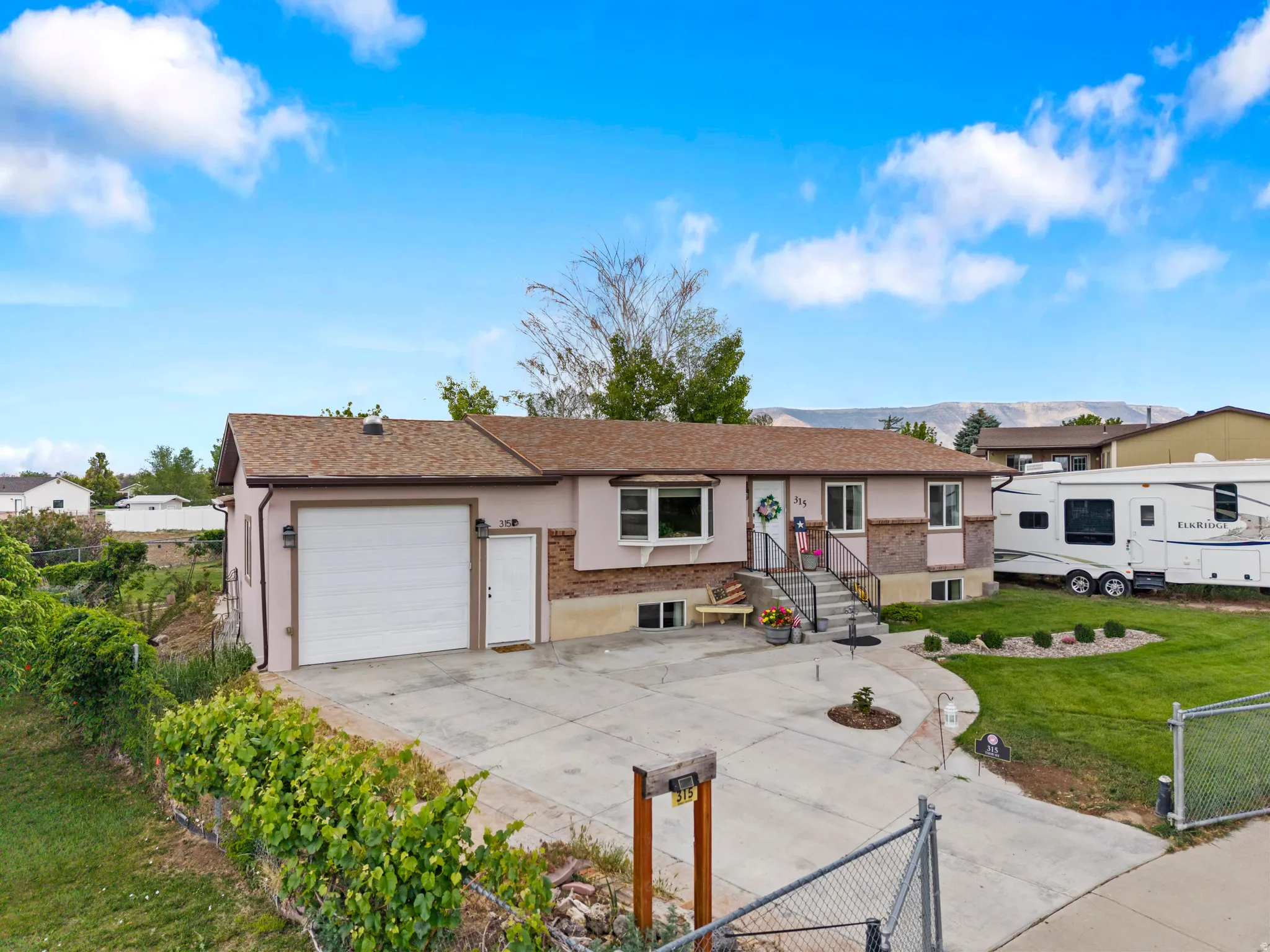 Single-story residence featuring a two-tone exterior with a stone veneer accent, an attached garage with a white door, and a concrete driveway