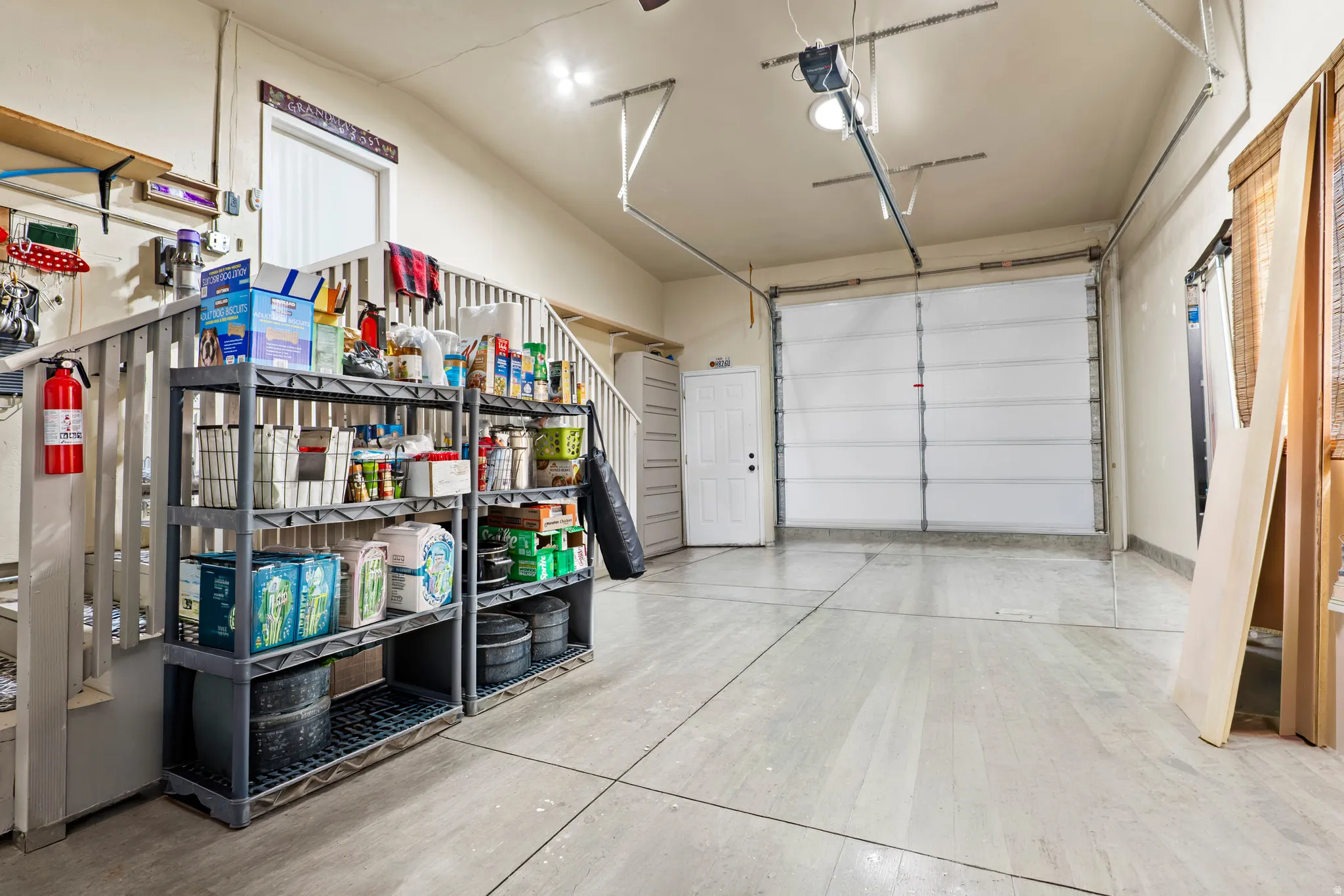 Spacious garage featuring a concrete floor, overhead lighting, and a white paneled garage door
