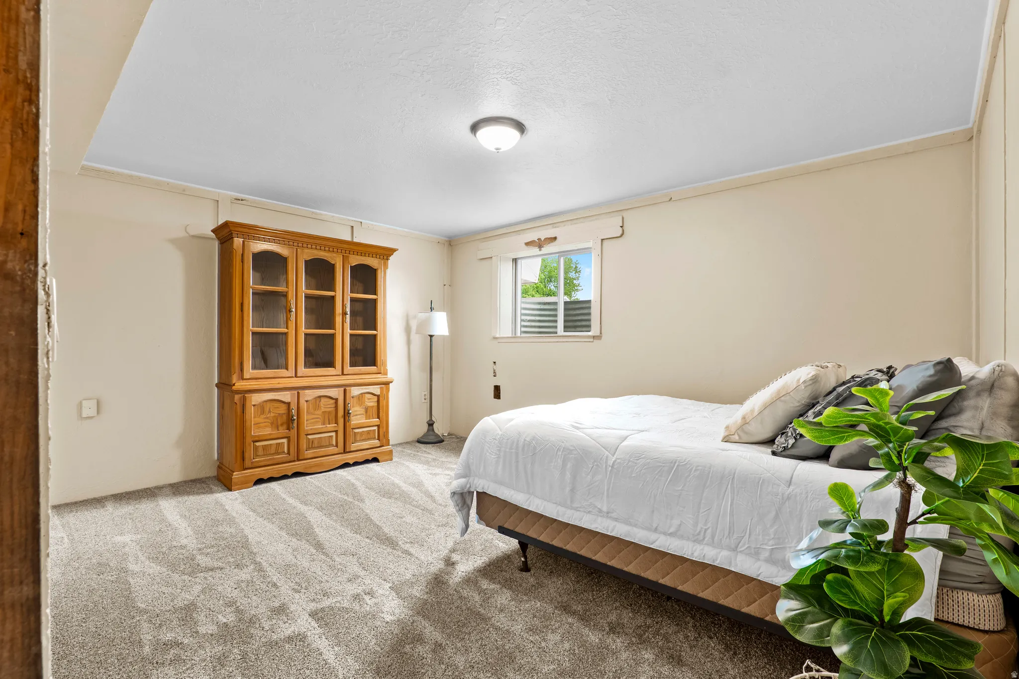 Spacious room featuring neutral-toned walls, recessed lighting, and soft, patterned carpeting