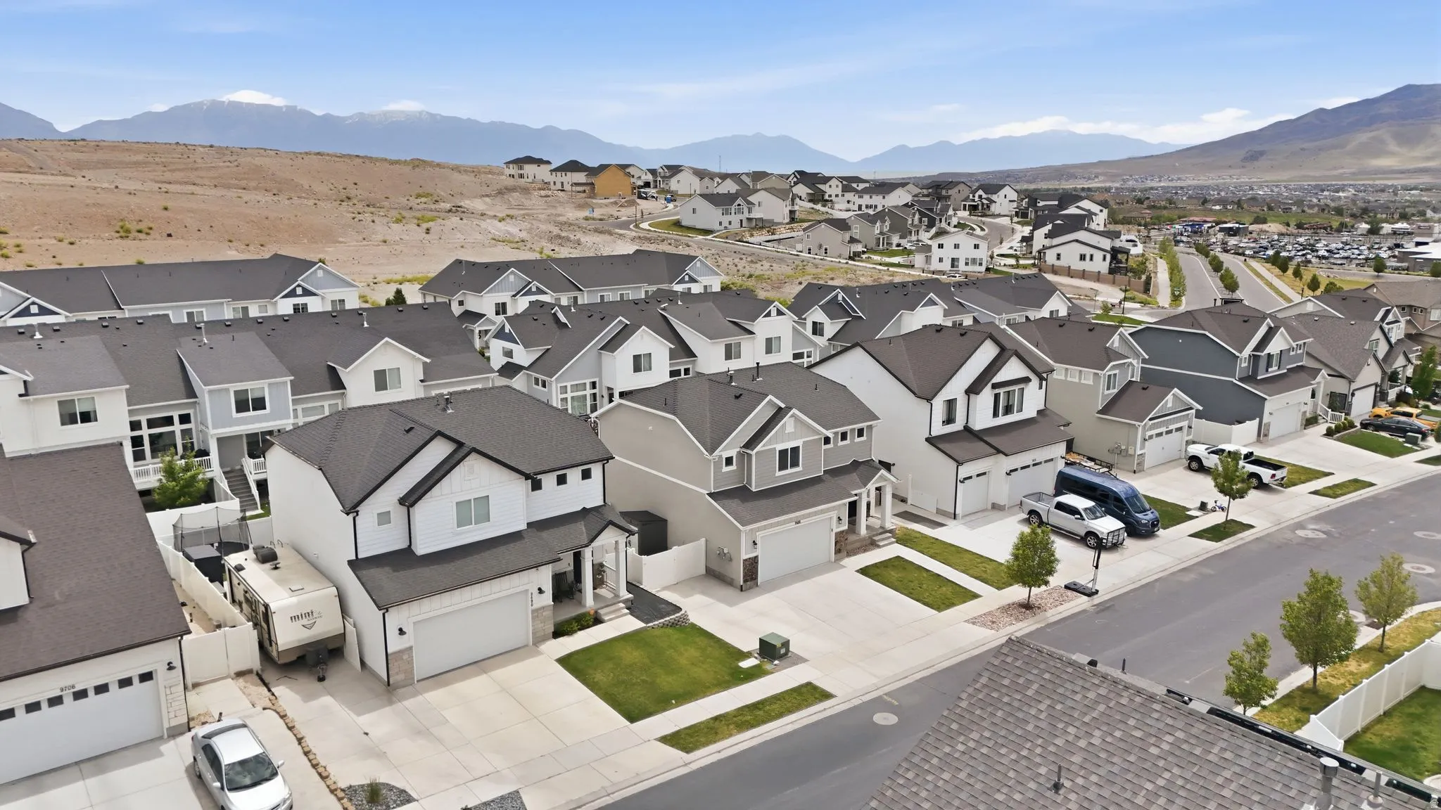 Modern residential development featuring a variety of architectural styles, paved roadways, and integrated landscaping elements