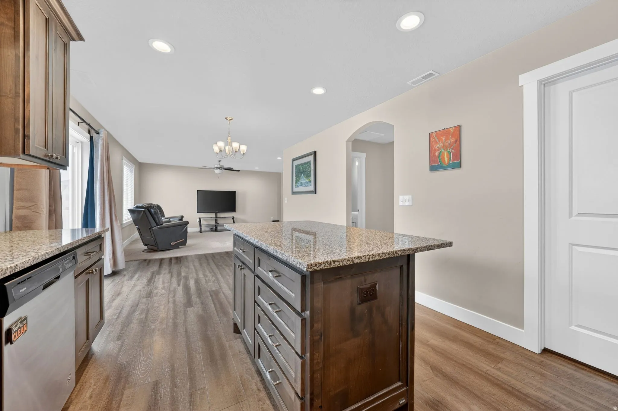 Kitchen island with a granite countertop and dark wood cabinetry