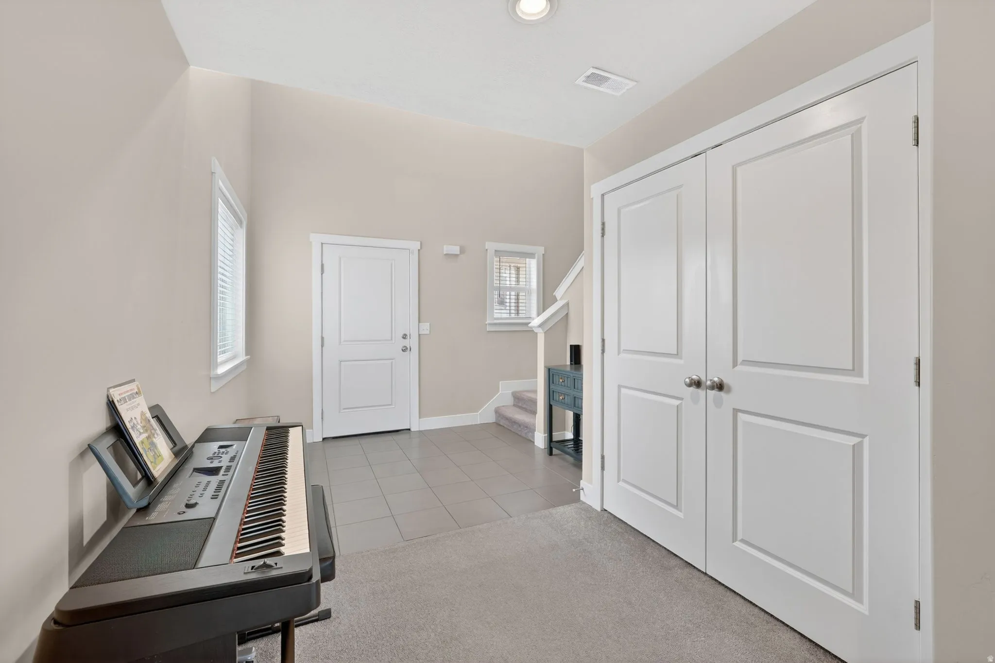 Entryway featuring a carpeted area and tile flooring