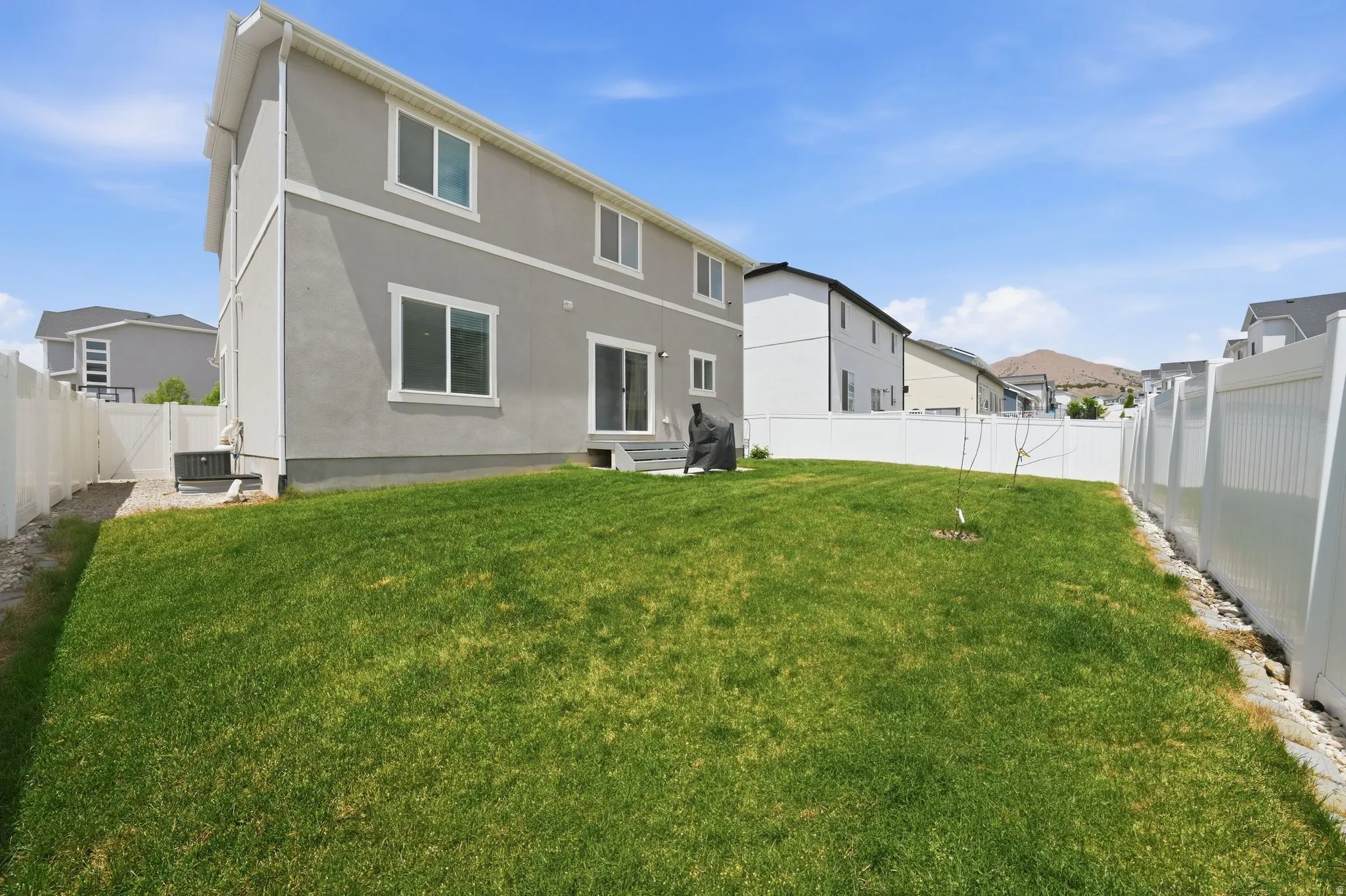 Spacious green lawn with complete white vinyl fencing