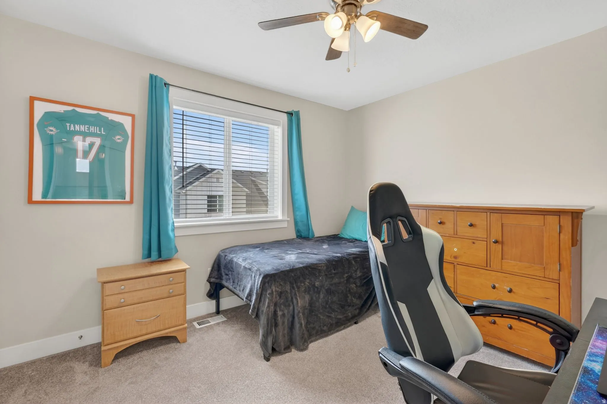 Carpeted room featuring a ceiling fan with light fixture, a window with horizontal blinds, and light-toned walls