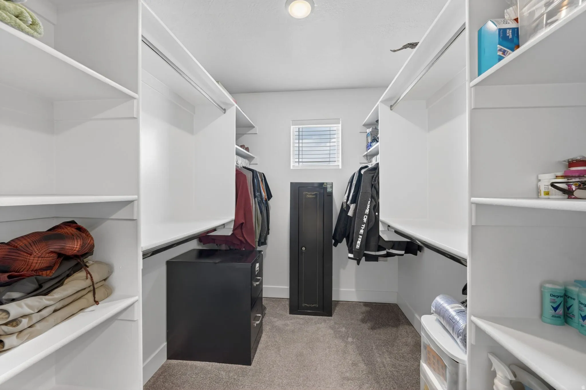 Walk-in closet featuring extensive white shelving and hanging rods