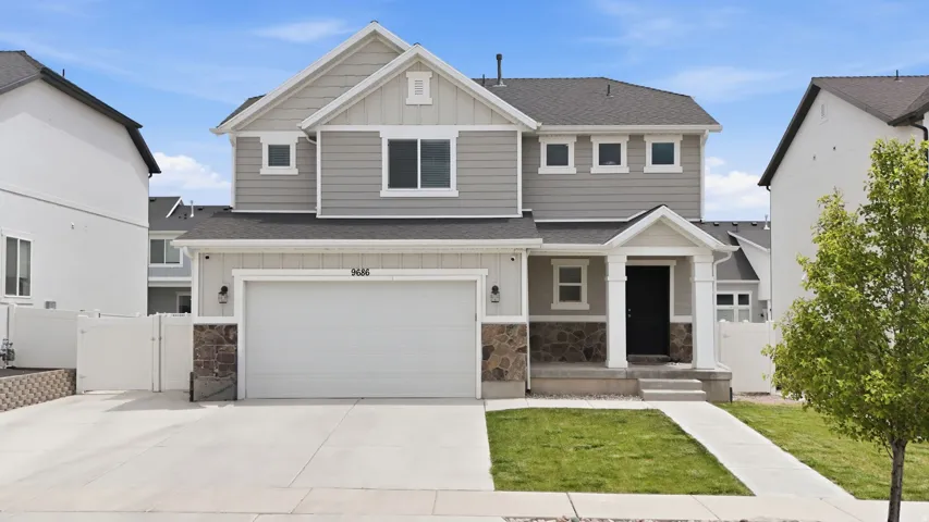 Contemporary two-story residence with a gray siding and stone veneer exterior