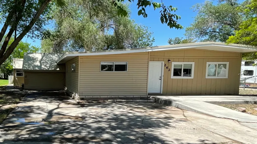 Single-story residence featuring light-colored siding and an attached garage