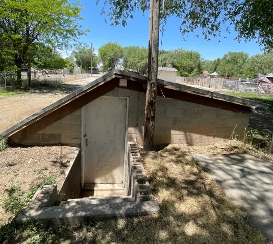 Exterior storage structure featuring concrete block construction and a sloped roof