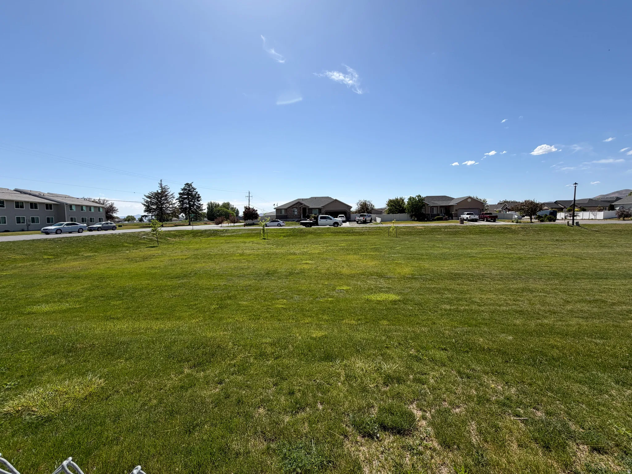 Expansive grassy lot featuring a clear, open space to the west of the home