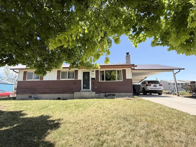 Rambler home featuring a metal roof and a covered carport