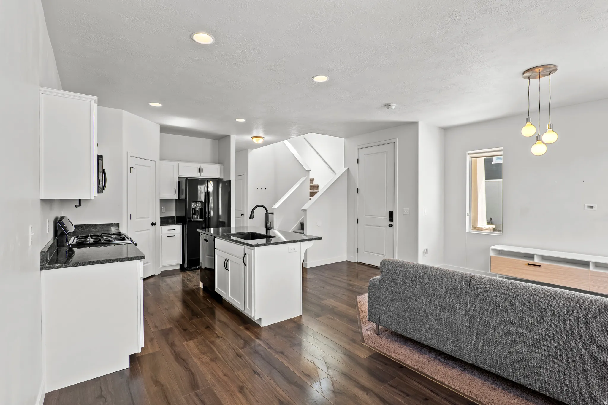 Open-concept living space featuring wood-finish flooring throughout the kitchen and living areas