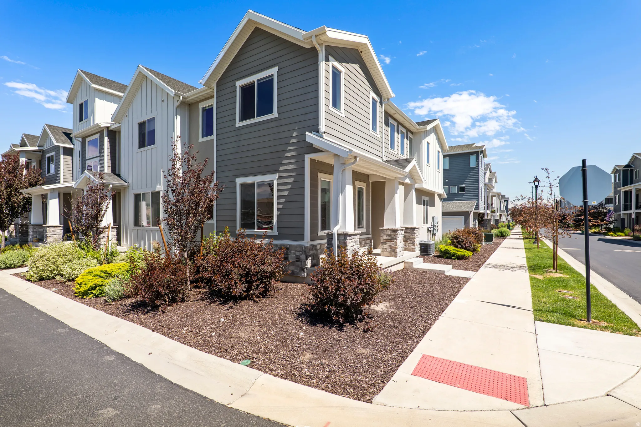 Modern townhome exterior featuring gray horizontal siding and white vertical board and batten accents