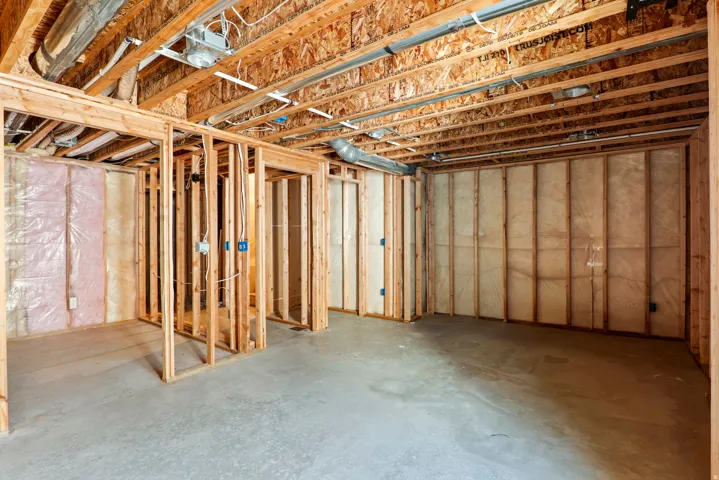 Unfinished basement offering exposed wood framing, concrete flooring, and visible insulation