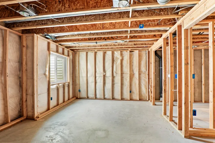 Unfinished basement featuring wood framing, exposed ceiling joists, and a concrete floor