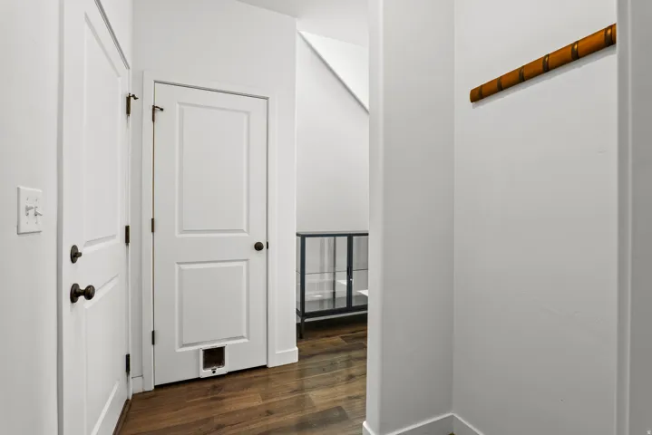 Entryway with wood-finish flooring, white paneled doors, and dark bronze door hardware