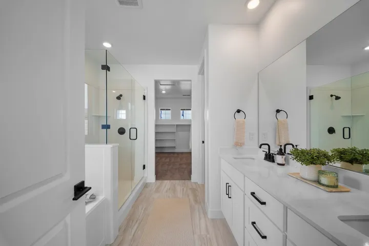 Contemporary bathroom featuring dual vanities with white cabinetry and quartz countertops