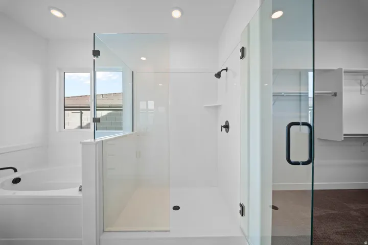 Walk-in shower with clear glass enclosure and matte black fixtures