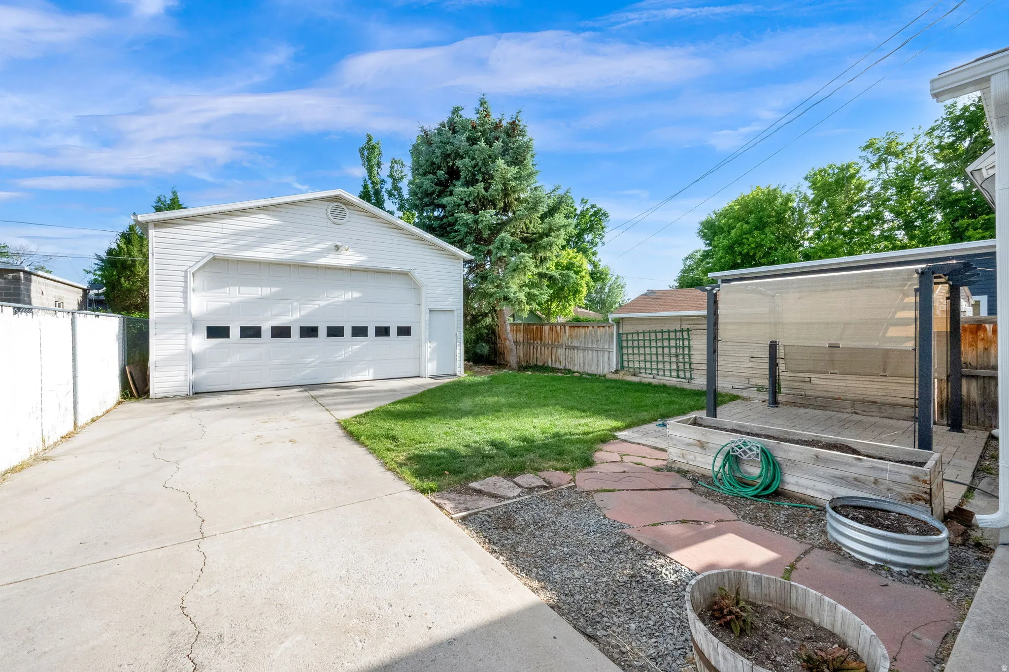 Detached two-car garage with a side entry door and concrete driveway
