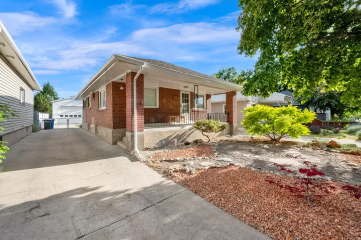 Brick exterior with a covered front porch featuring wrought iron railings Driveway to oversized double car garage.