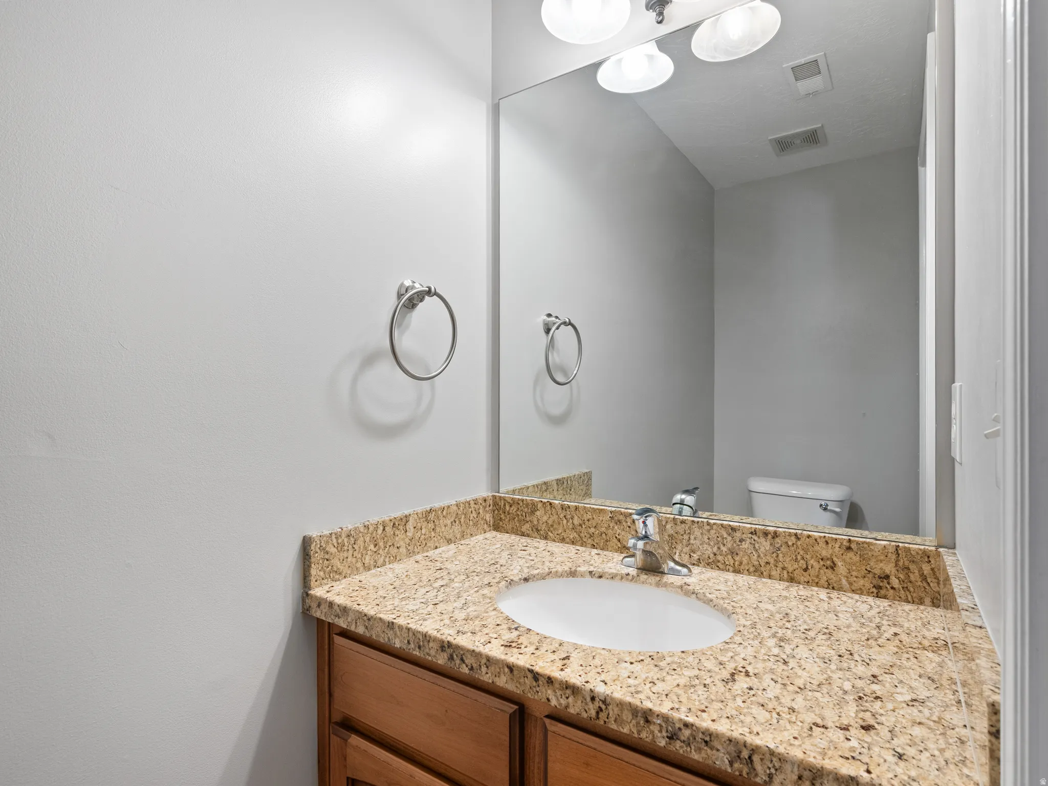 Vanity with a granite-style countertop and an undermount sink