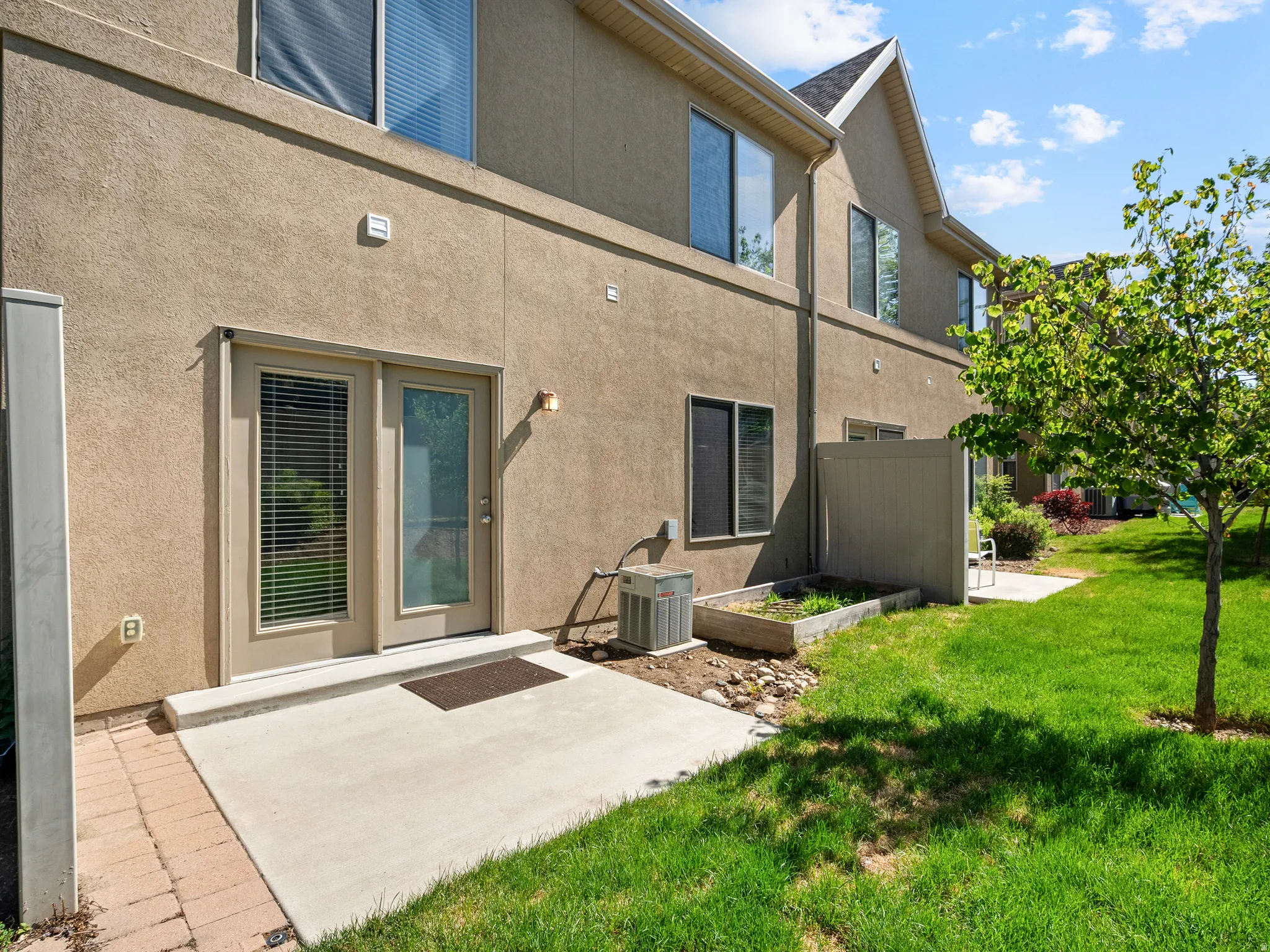 Private concrete patio with direct outdoor access and a manicured lawn