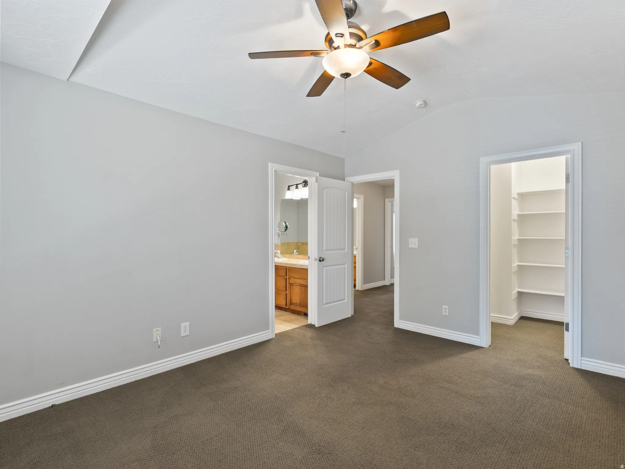 Room featuring vaulted ceilings and a ceiling fan with light fixture