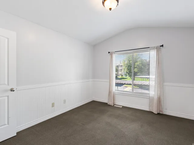Interior room with wainscoting and a vaulted ceiling