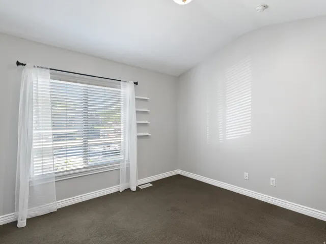 Neutral wall tones complement the dark carpet flooring