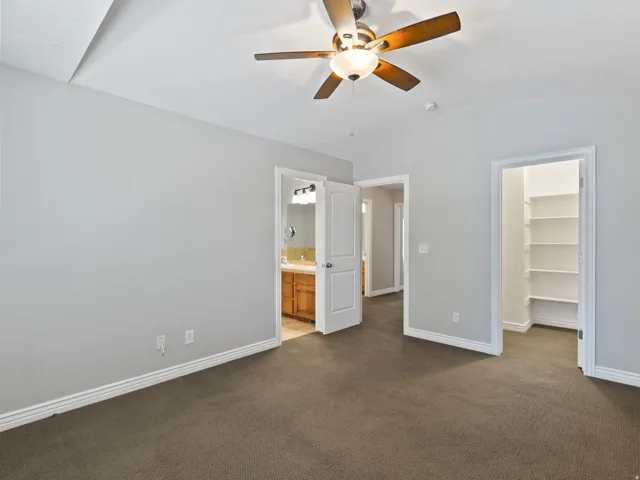 Room featuring vaulted ceilings and a ceiling fan with light fixture