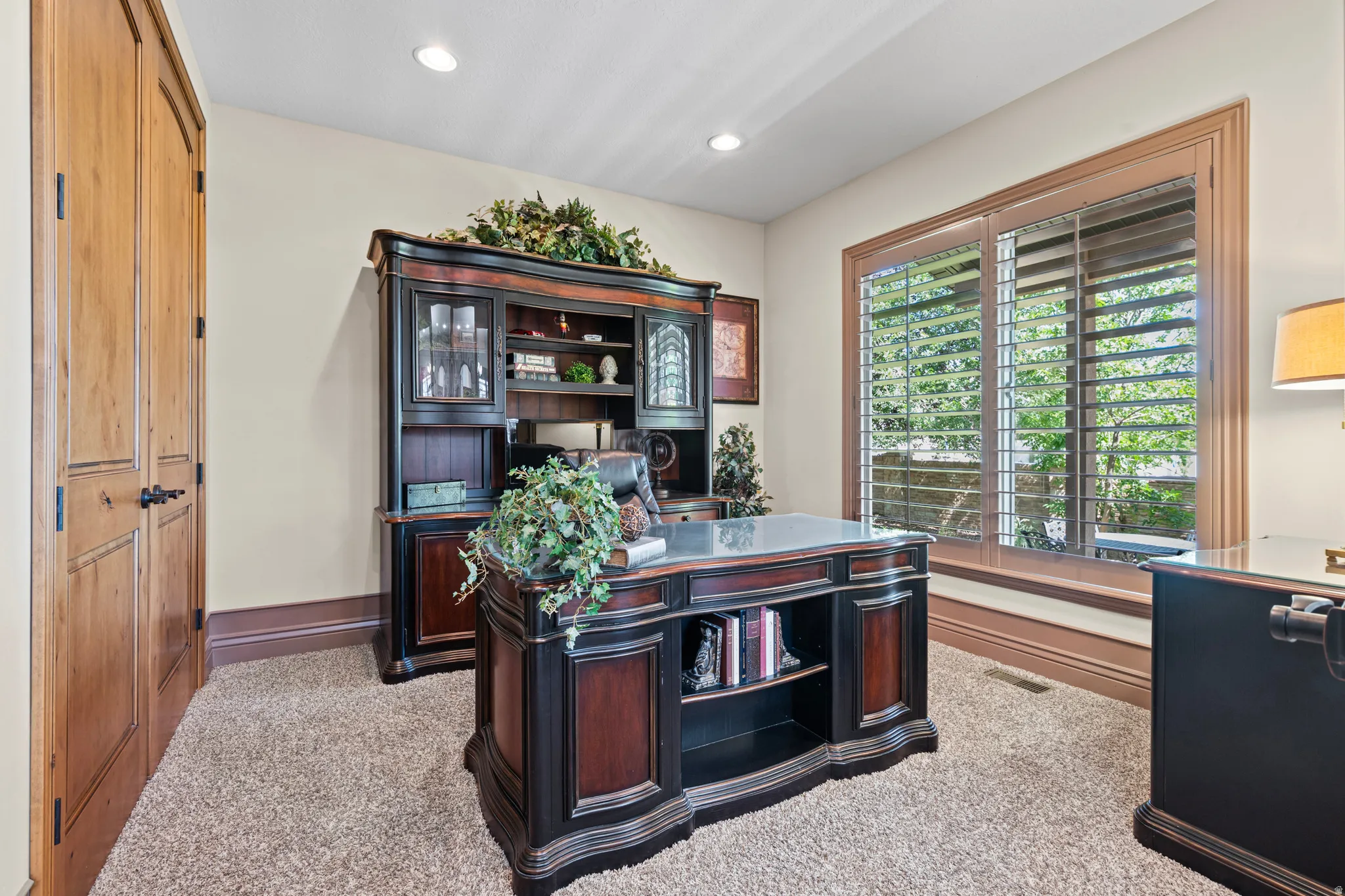 Room featuring a double door entry with dark hardware, recessed lighting, and a large window with plantation shutters