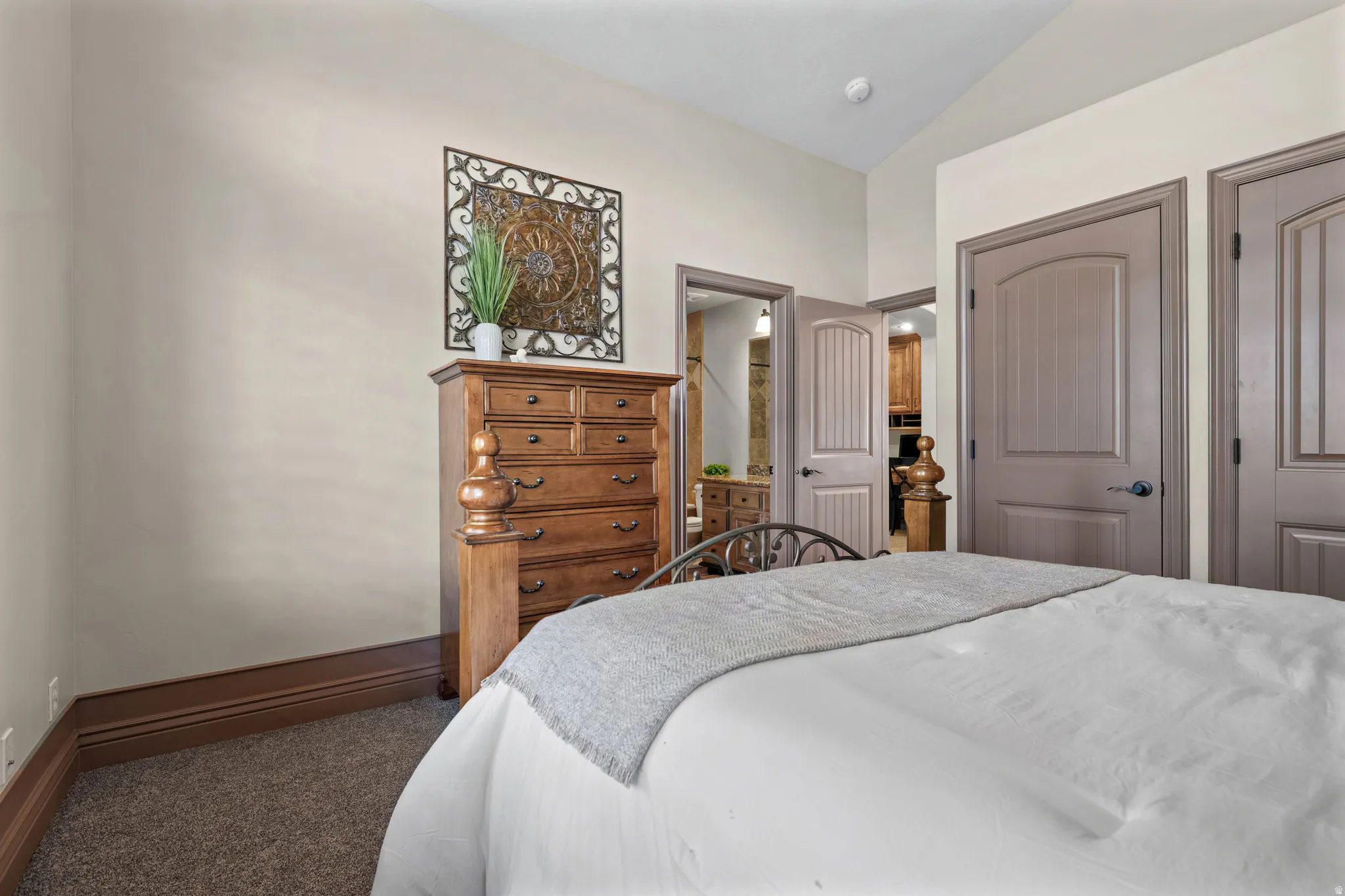 Carpeted bedroom with neutral wall paint and dark wood baseboards