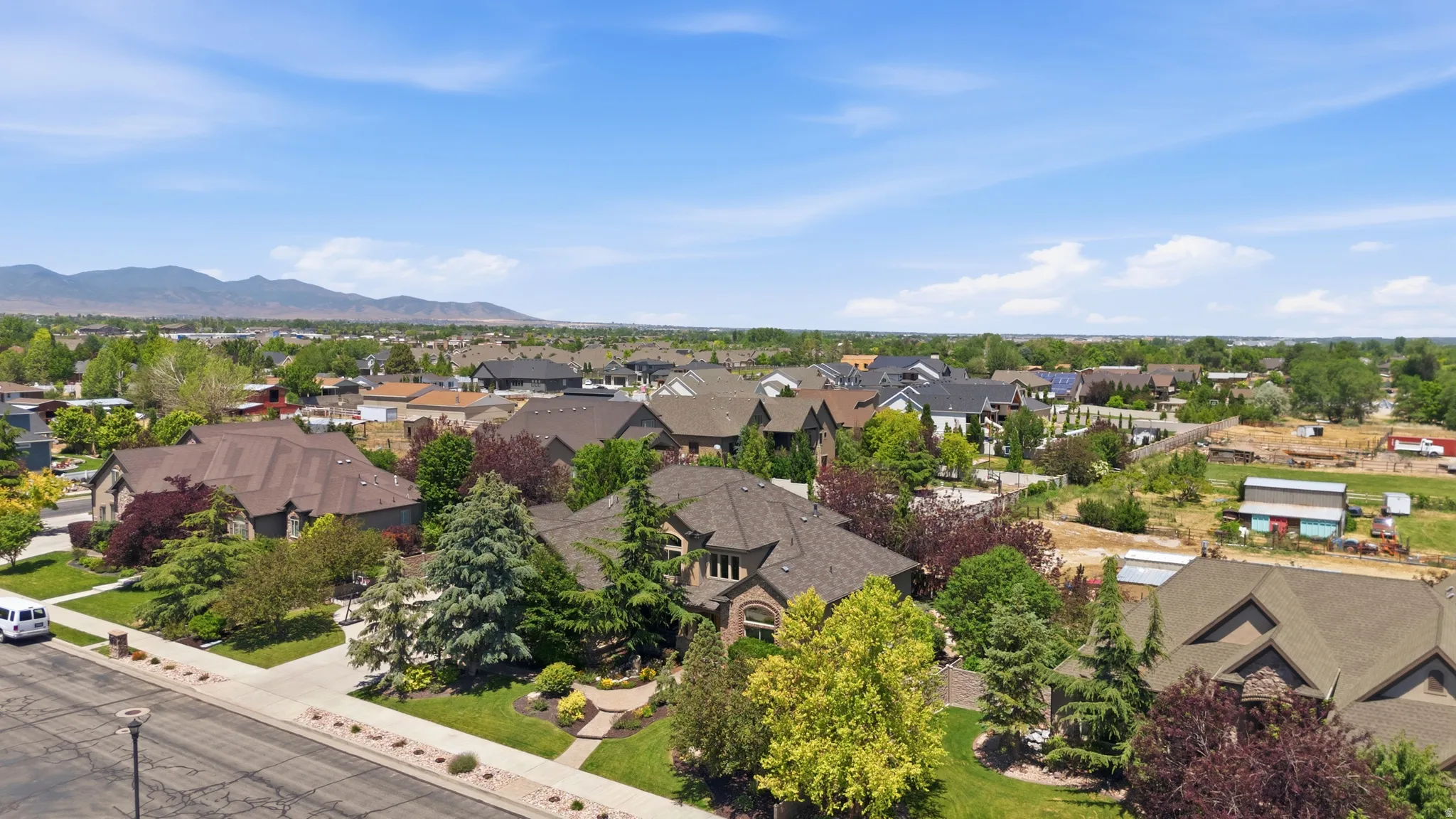 Residential neighborhood with established homes, mature landscaping, and a distant mountain backdrop