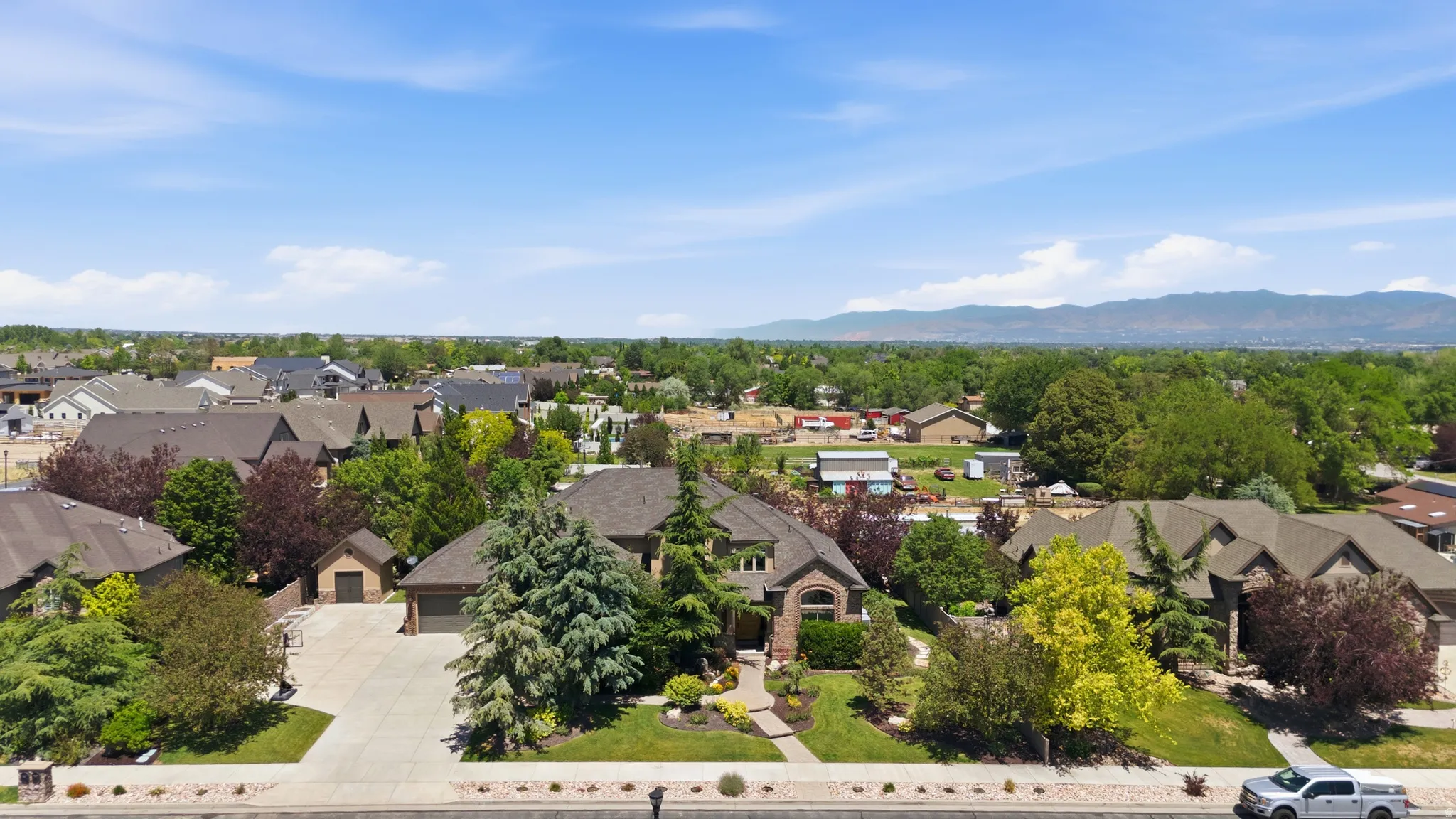 Traditional-style residence featuring a prominent arched entry, a concrete driveway, and an attached two-car garage
