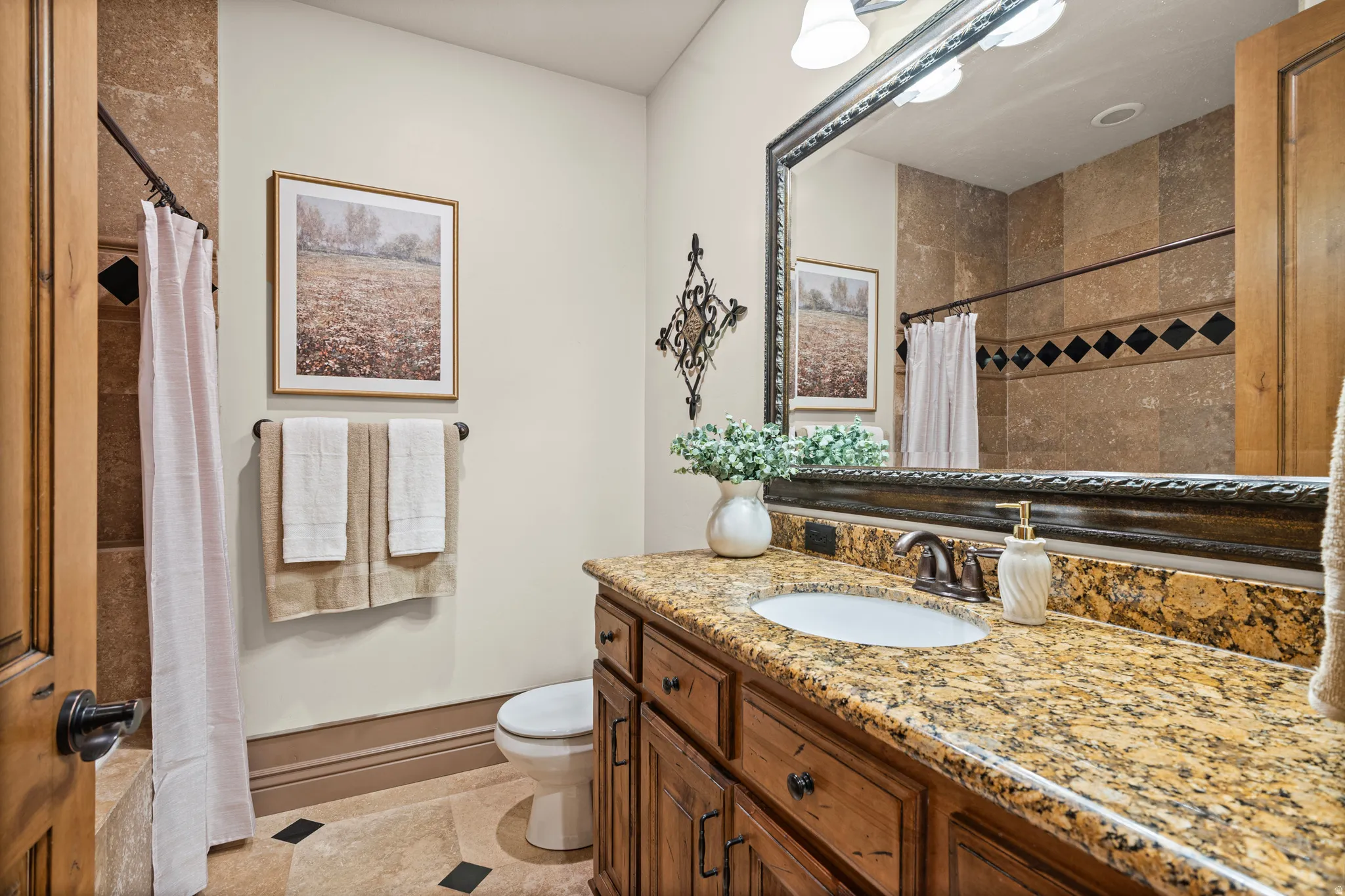 Bathroom featuring a wood vanity with a granite countertop and an undermount sink
