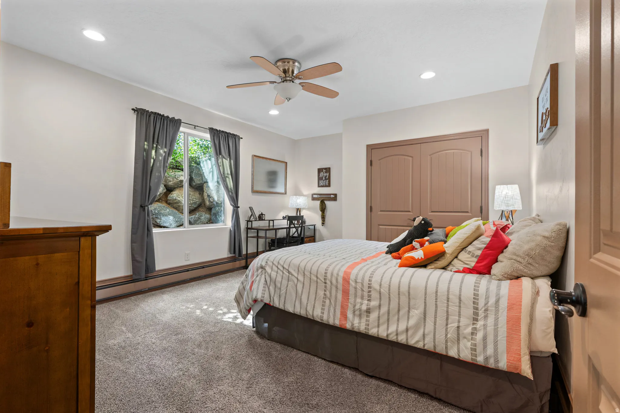 Spacious room featuring neutral carpeting, a dual-door closet, recessed lighting, and a ceiling fan with integrated lighting