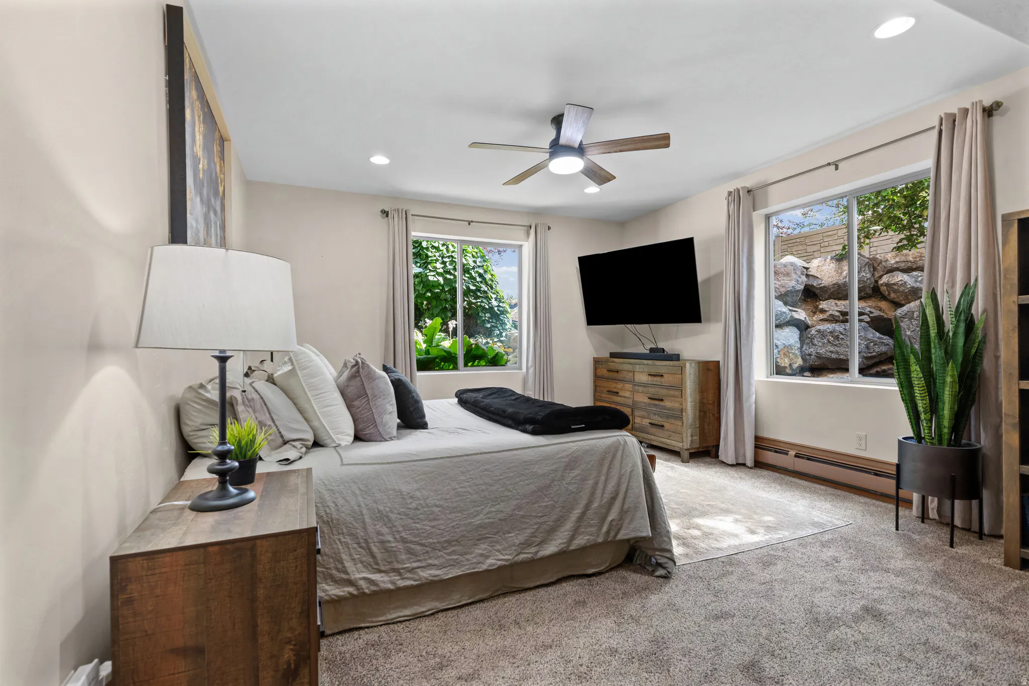 Carpeted room featuring multiple windows with outdoor scenery, recessed lighting, and a ceiling fan