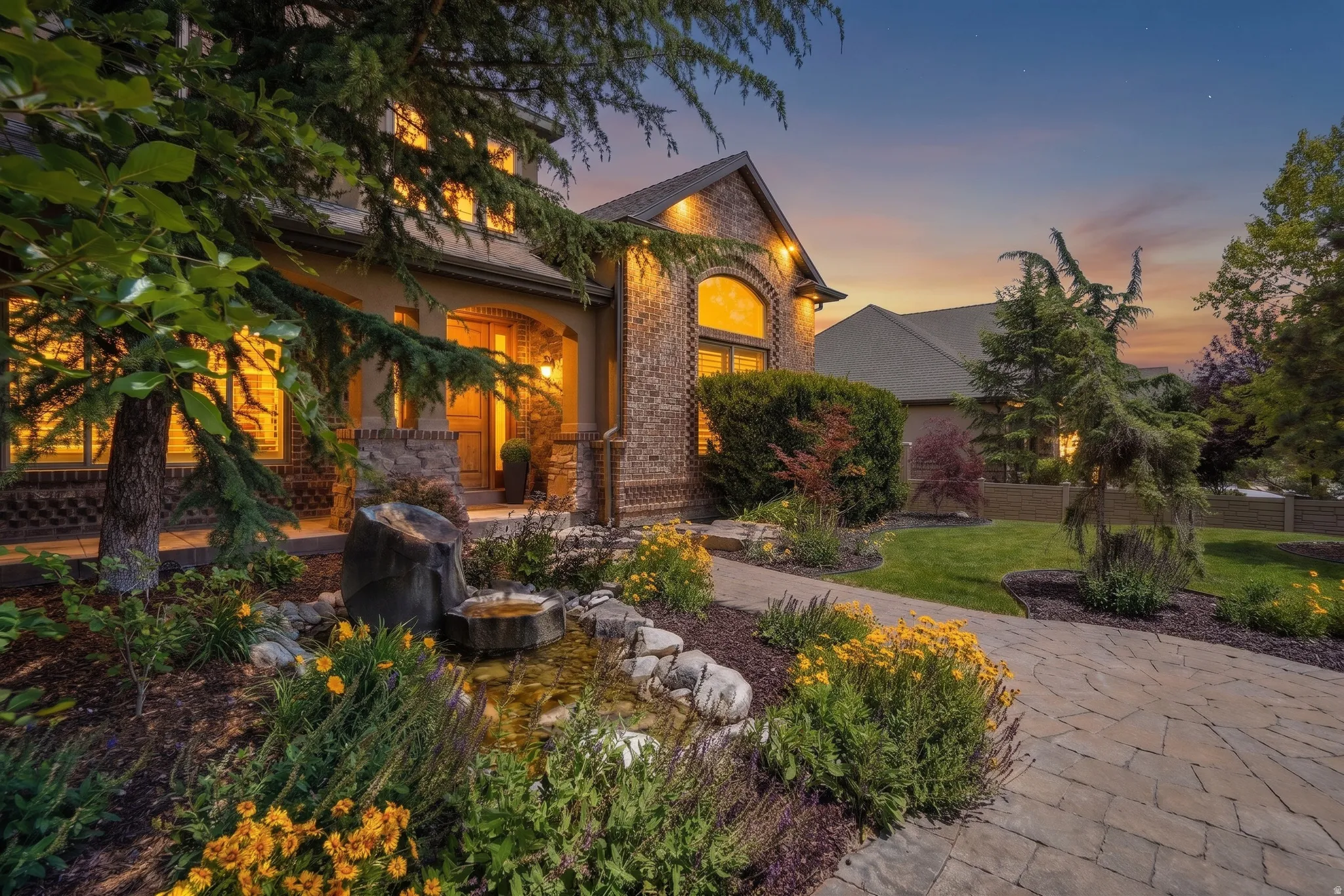 Stately brick, stone and stucco exterior residence featuring arched windows and a covered entry