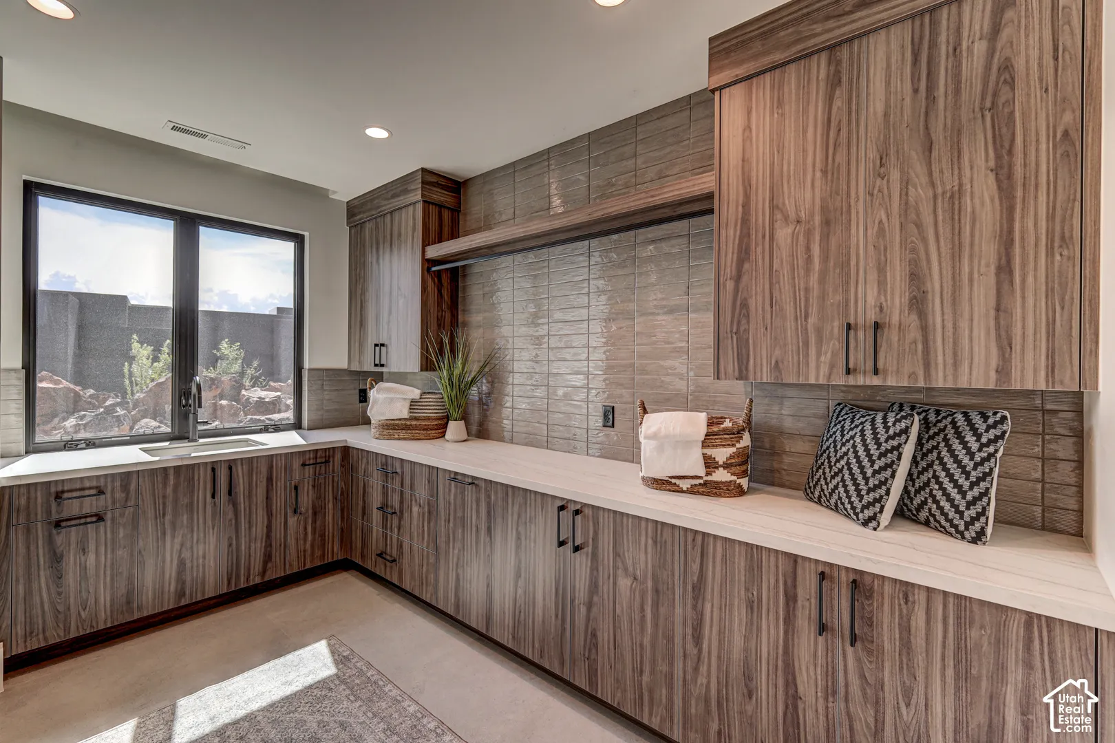 Full height cabinetry with dark hardware, expansive countertop space, and a built-in hanging rod